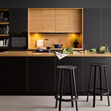 Einbauküche schwarz matt kombiniert mit Eiche hell, Arbeitsinsel mit Plattenüberstand als Barlösung